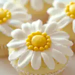 A party dessert table featuring daisy cupcakes alongside lemon bars and sugar cookies for a fresh, floral theme.