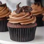 A rustic wooden background featuring a group of chocolate cupcakes in paper liners, freshly frosted and ready to serve.