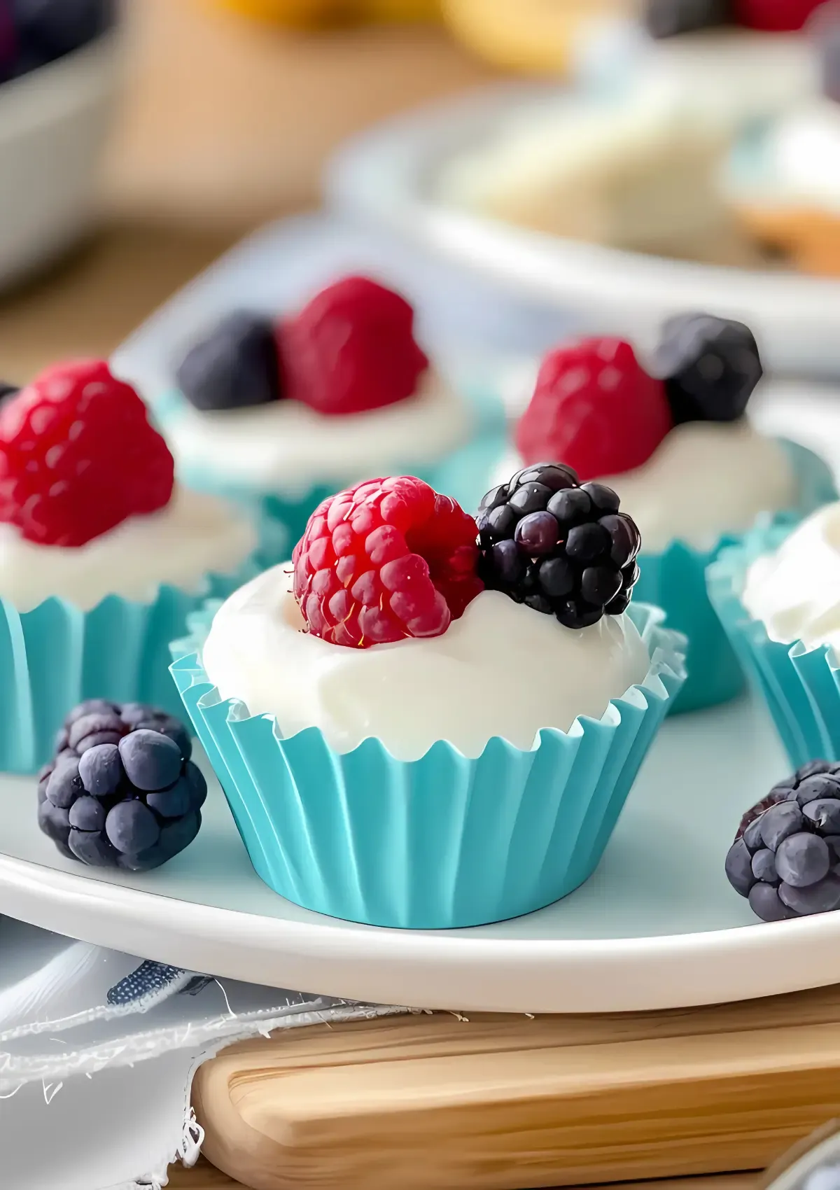 Pinterest-ready image of vegan frozen yogurt cups in teal liners with fresh berries on a white plate, featuring text overlay reading '3-INGREDIENT VEGAN FROYO CUPS' and website URL oliviahealthyliving.com.