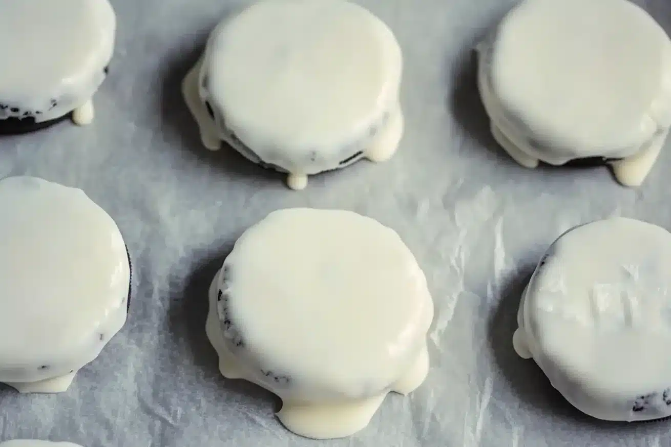 White chocolate dipped Oreos on parchment paper - first step in making Red White & Blue Oreos