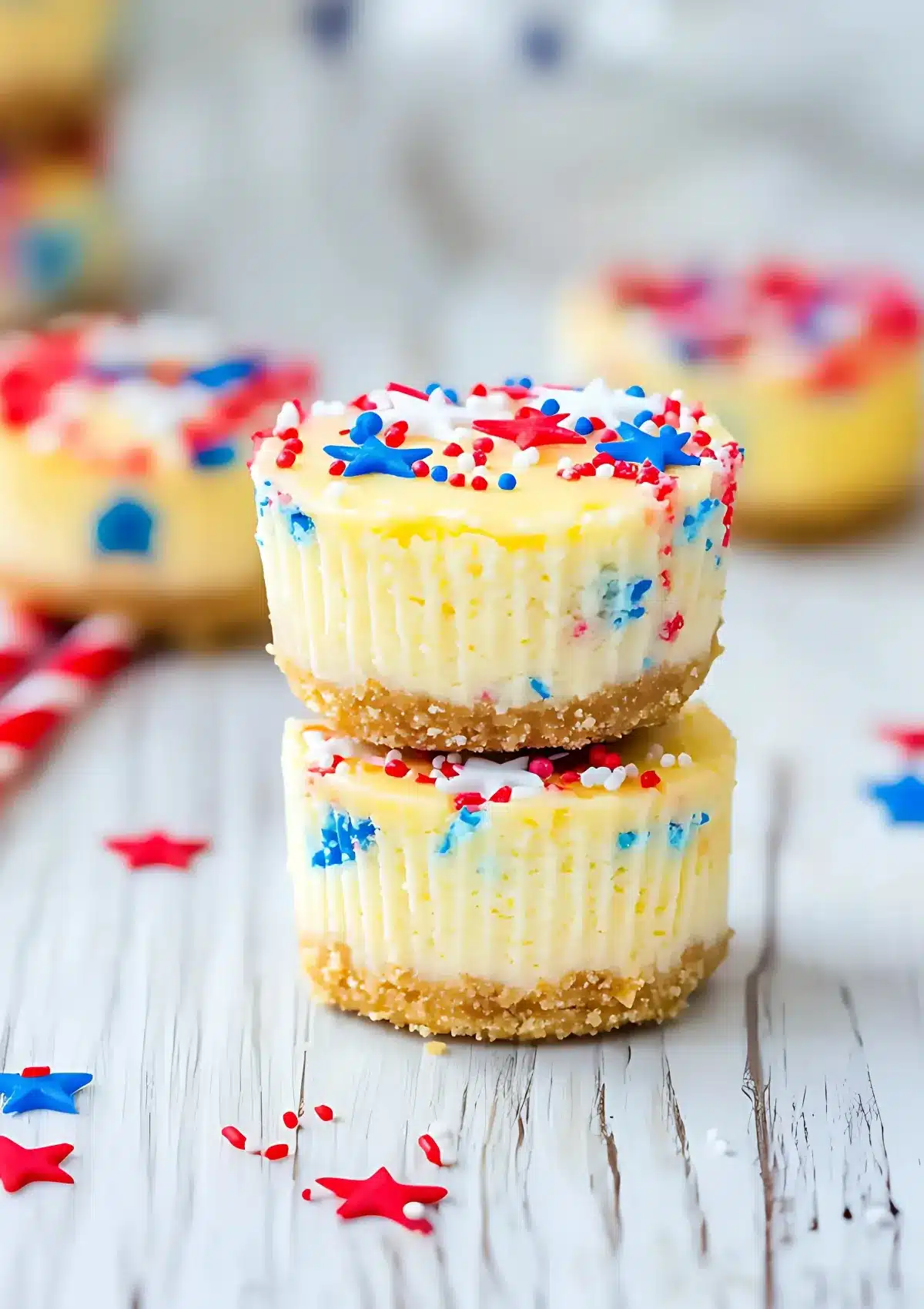 Bowl of cheesecake batter with red and blue sprinkles arranged in separate piles on top, sitting on an American flag patterned surface