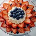 Circular pattern of sliced strawberries and blueberries decorating the top of a no-bake 4th of July trifle dessert