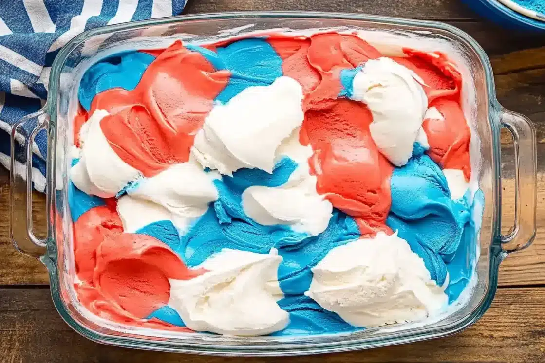 Glass baking dish filled with marbled red, white and blue ice cream mixture before freezing, shown from above