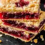 Cross-section view of cherry pie bars revealing layers of pastry and cherry filling with fresh cherries