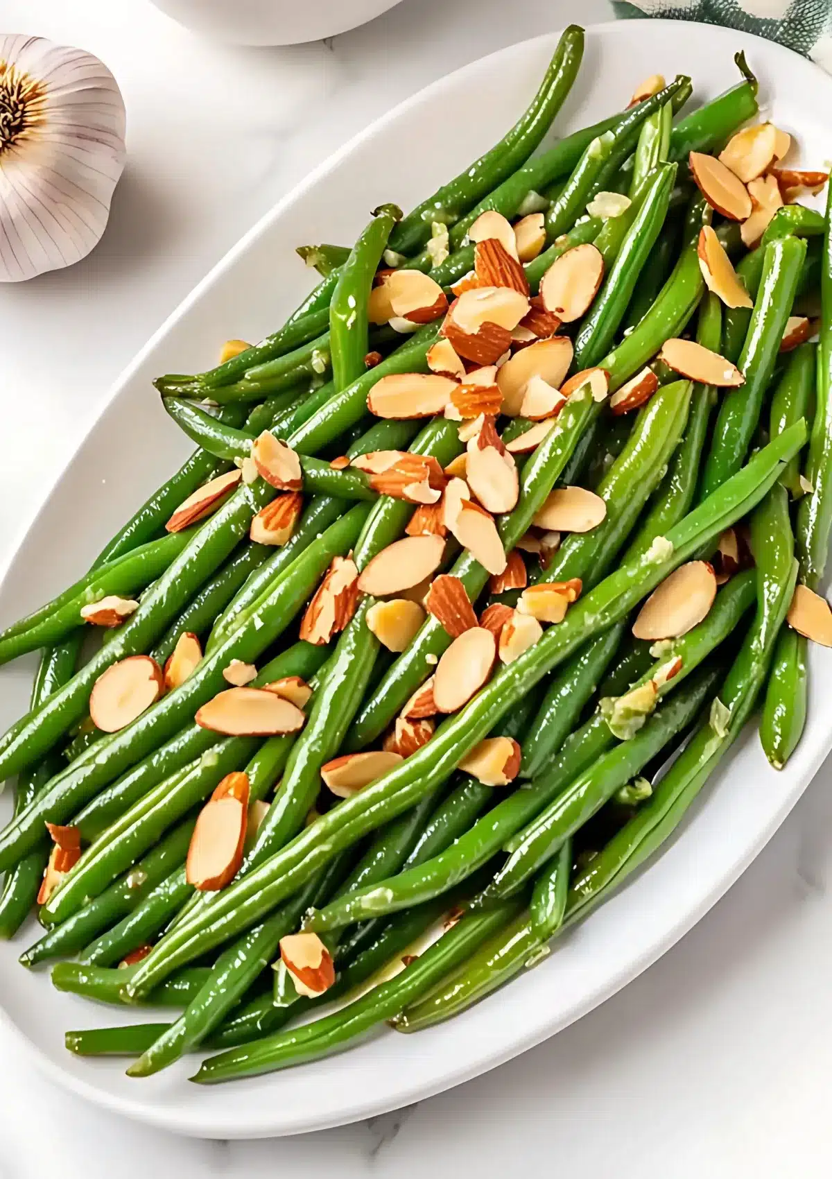 Close-up of green beans almondine showing crisp tender green beans topped with golden slivered almonds