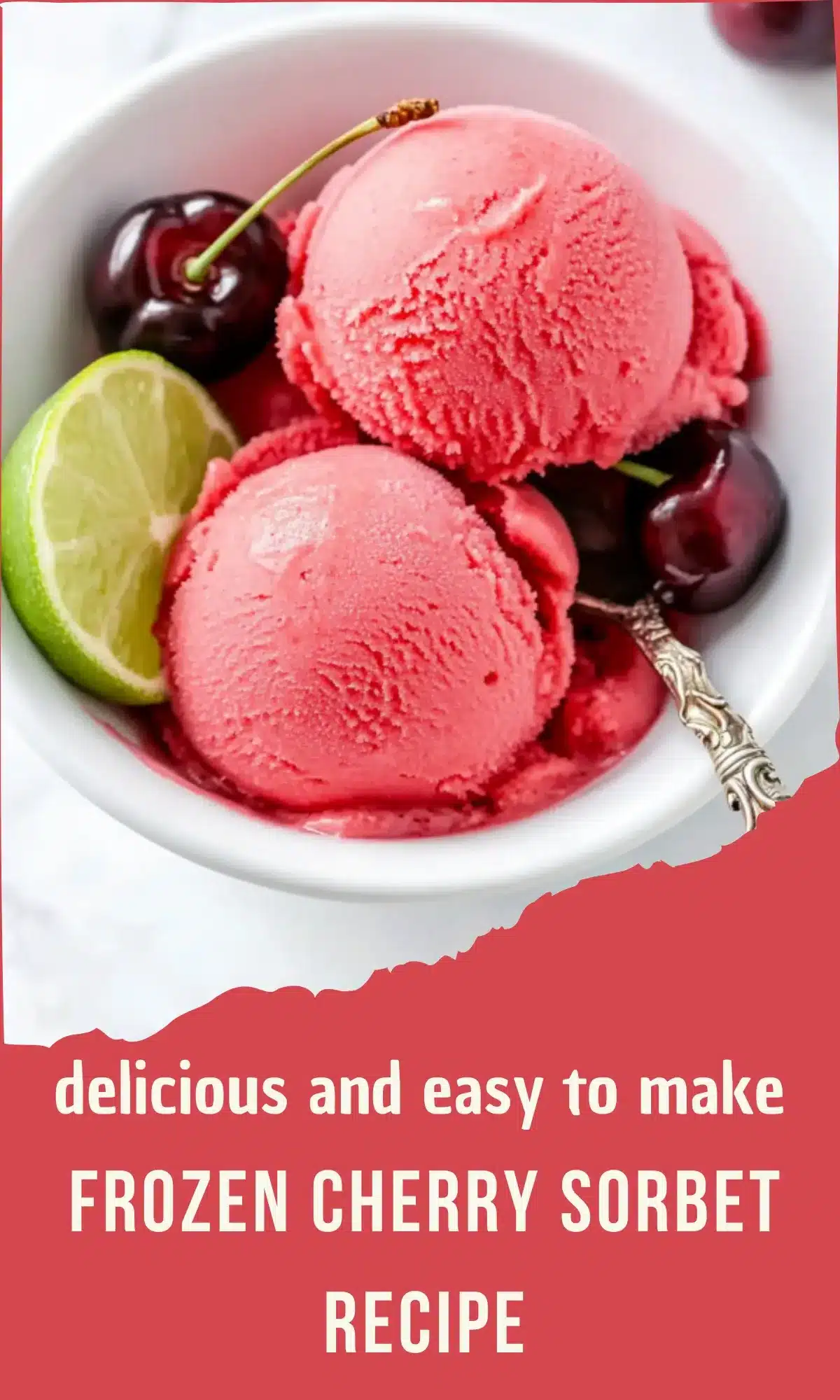 Two scoops of pink cherry sorbet served in a white bowl with fresh cherries and lime wedge garnish