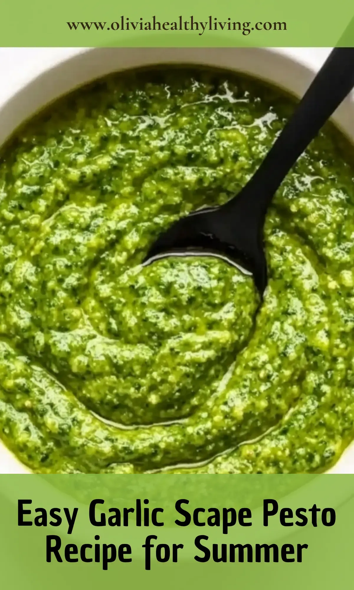 Creamy green garlic scape pesto in food processor bowl with black spoon showing smooth texture