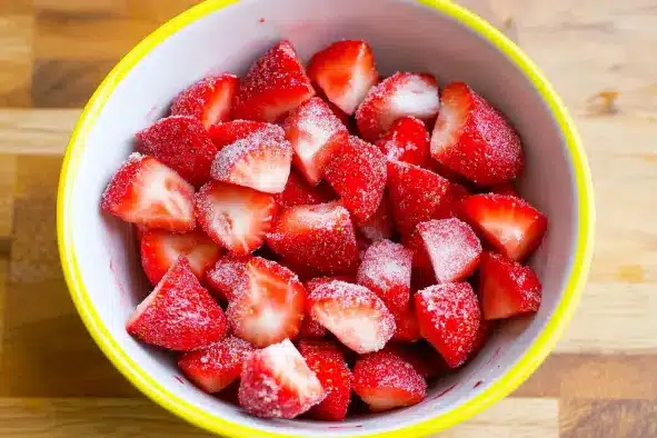 Bowl of fresh strawberries sliced and sugared for strawberry shortcake recipe