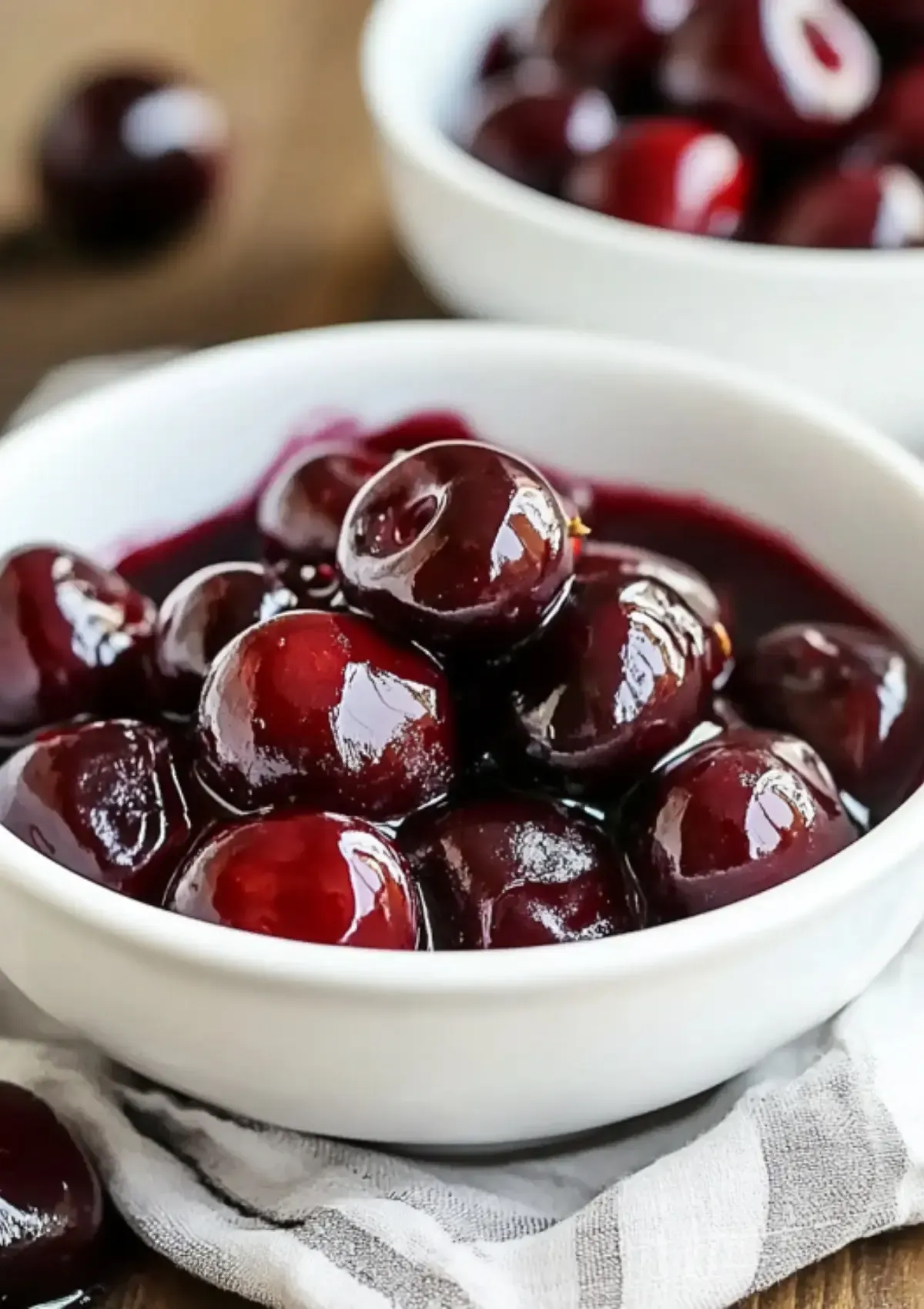 Bowl of roasted cherries with rich, syrupy juices and caramelized edges