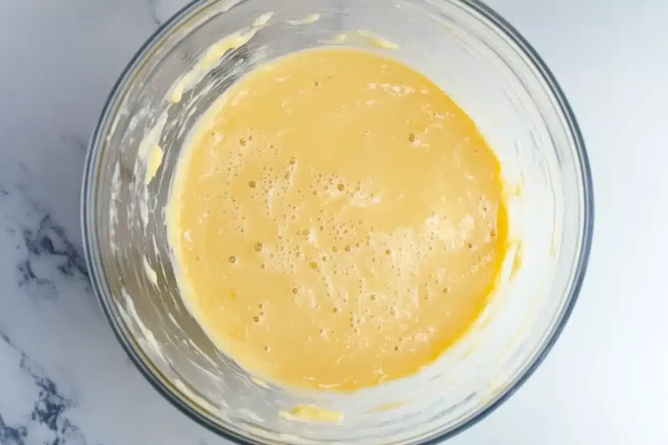 Glass bowl with beaten eggs mixed into creamed butter and sugar for frangipane