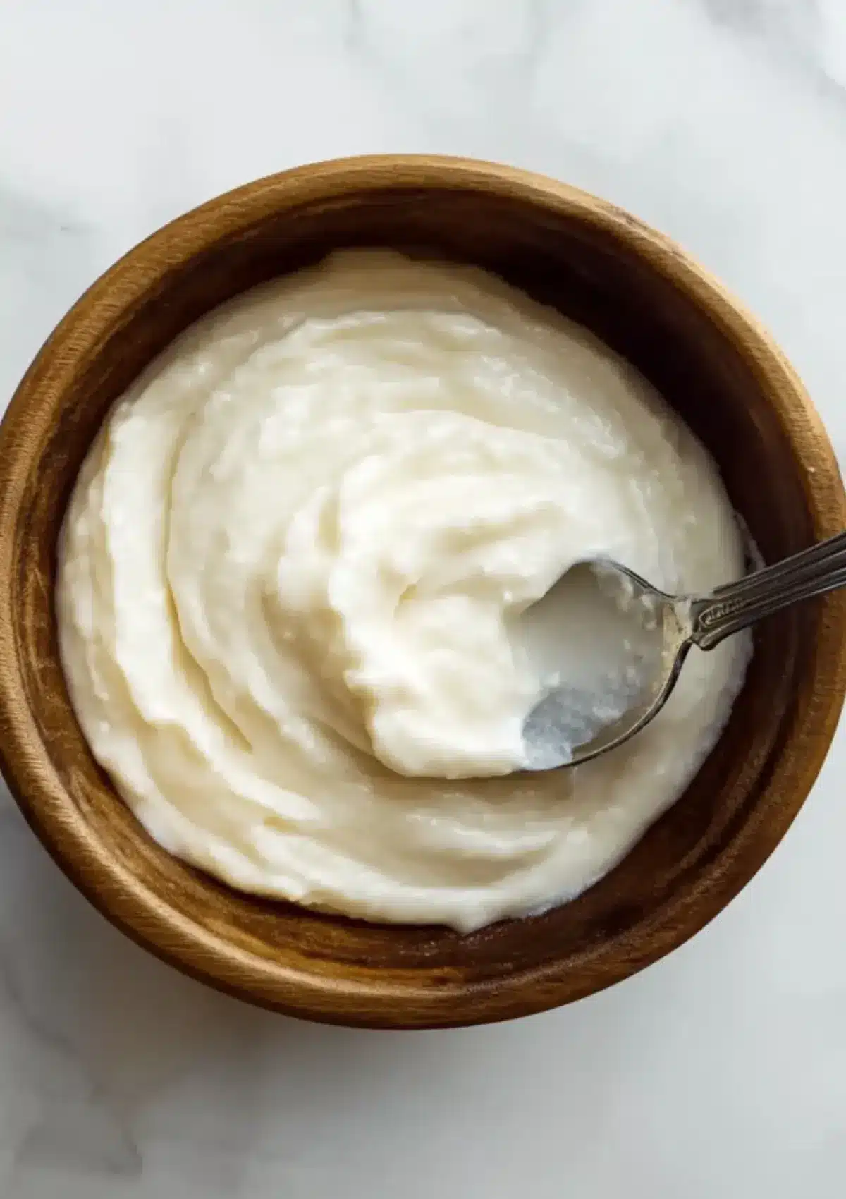 Creamy Toum garlic sauce in a wooden bowl with spoon