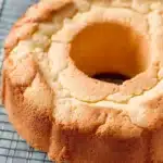 Freshly baked cream cheese pound cake cooling on a wire rack showing the beautiful golden brown crust and classic bundt shape