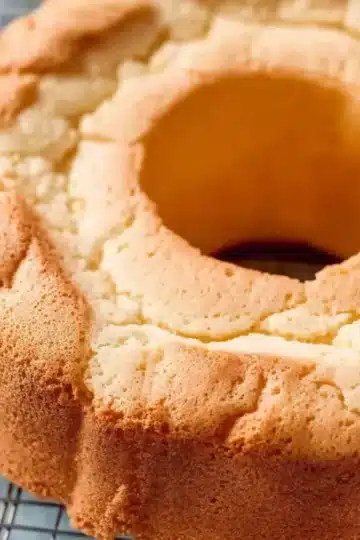 Freshly baked cream cheese pound cake cooling on a wire rack showing the beautiful golden brown crust and classic bundt shape