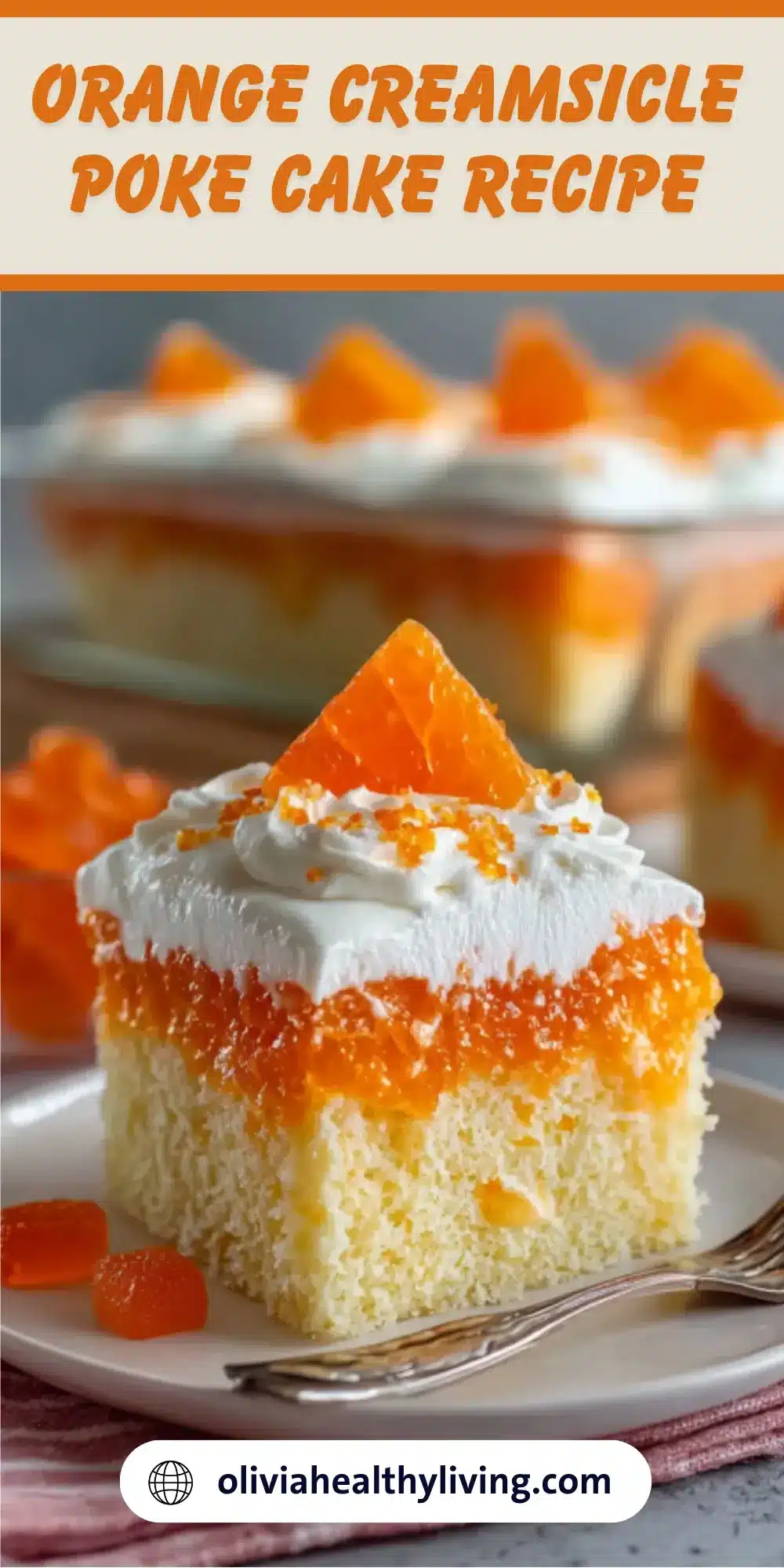 Orange creamsicle poke cake slice on white plate with fluffy white topping and orange candy garnish, showing layered cake with orange jello filling