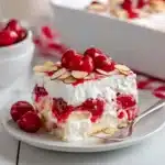 Easy Heaven on Earth Cake showing creamy white layers with red cherry swirls and almond slices on top