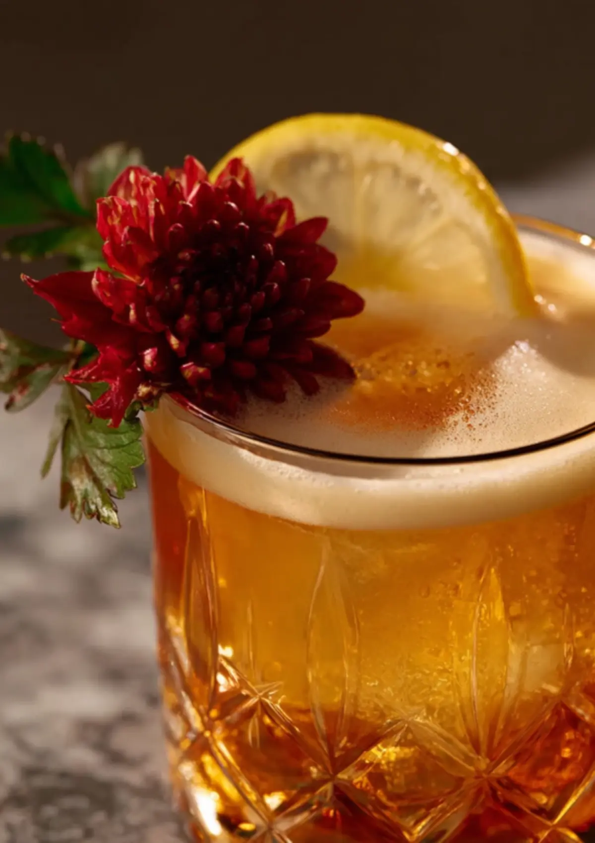 Detail view of layered amber cocktail with creamy foam top