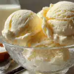 Two perfect scoops of vanilla ice cream in textured glass bowl with milk and vanilla beans on marble surface - Copy