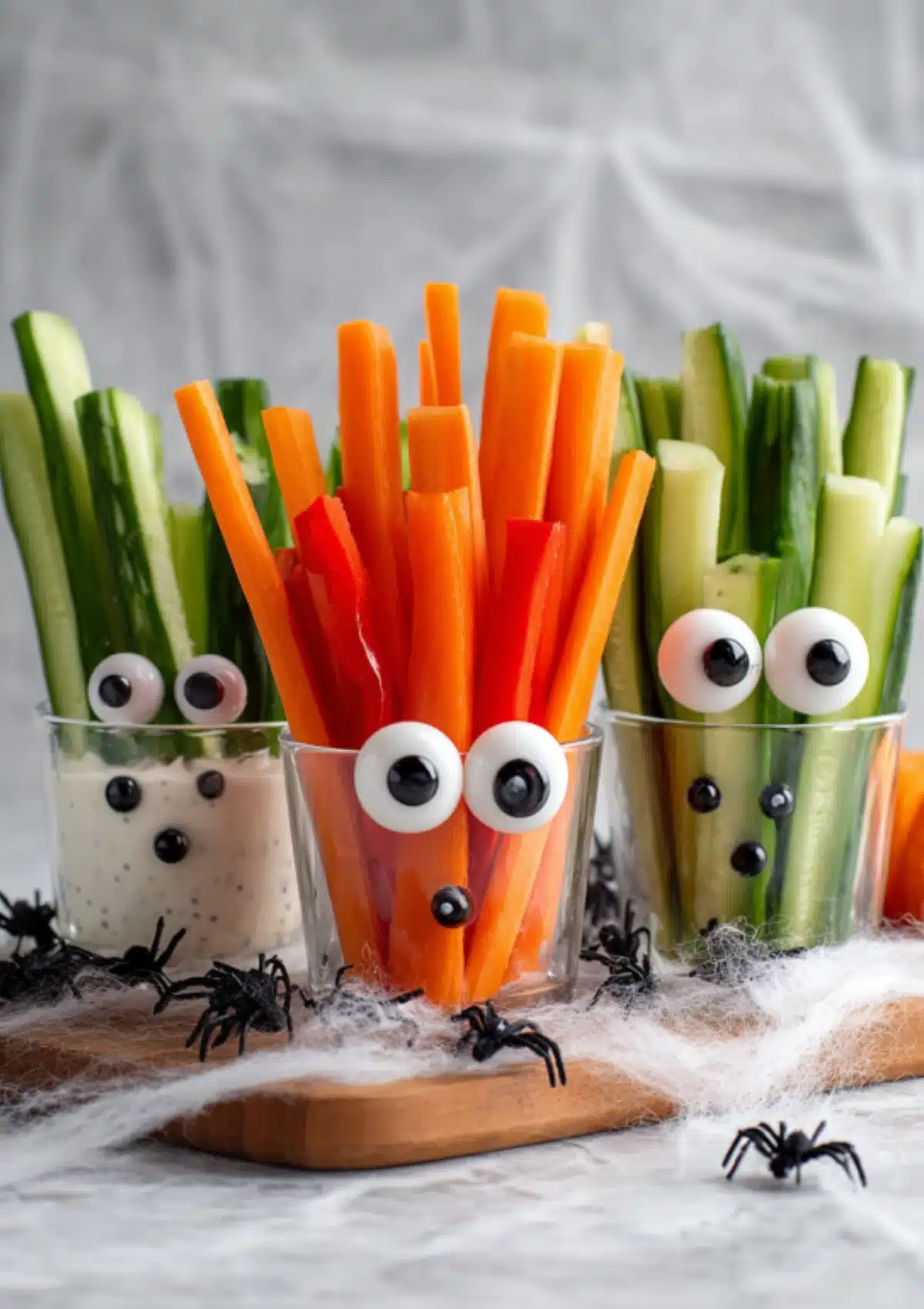 Close-up of three monster veggie glasses with googly eyes