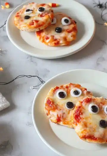 Mummy pizzas on marble surface with Halloween decorations