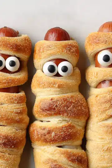 Spooky mummy wrapped hot dogs with candy eyes