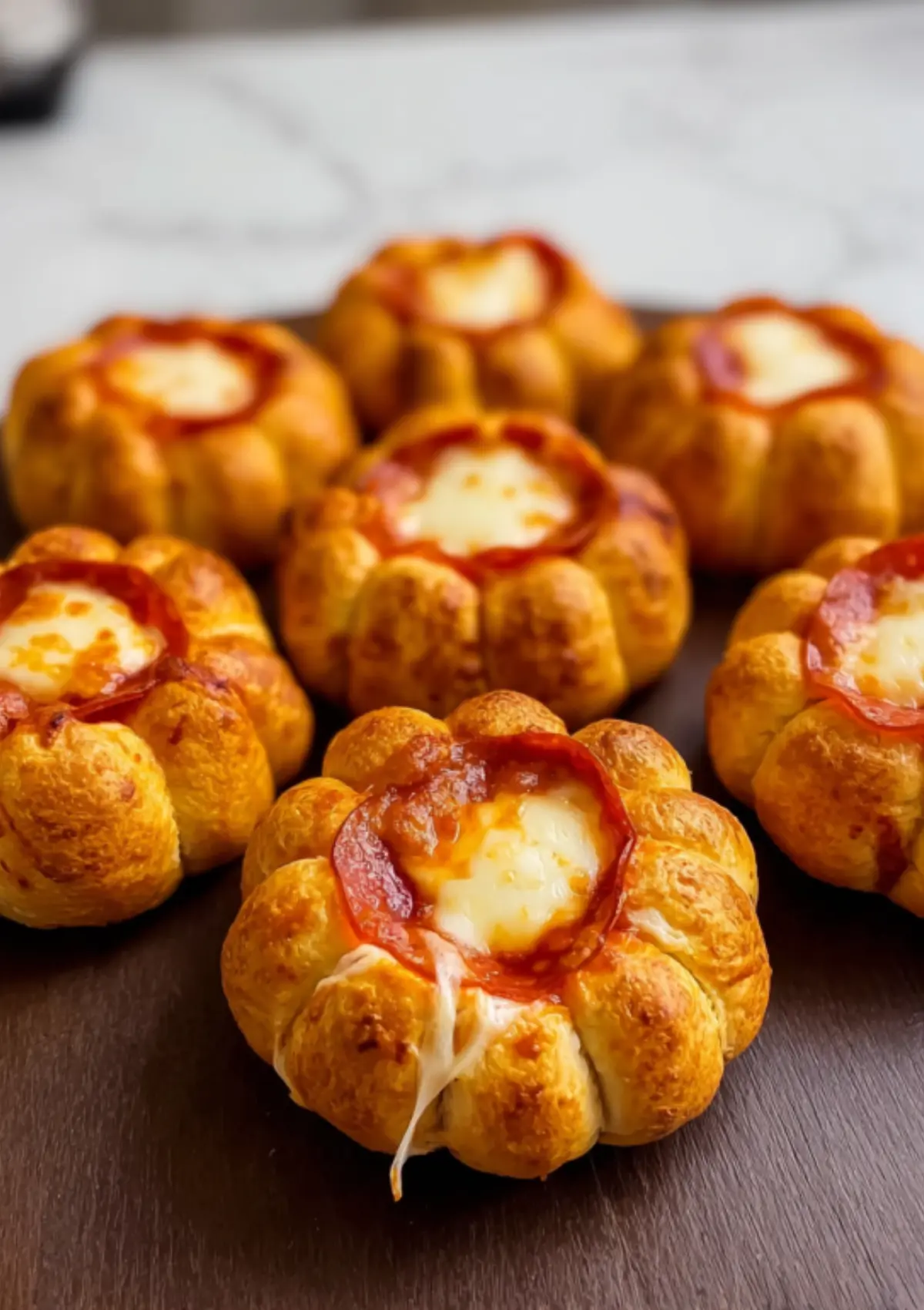Close-up of pumpkin pizza bombs with stretchy melted cheese