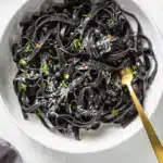 Close-up of squid ink pasta with parmesan and red pepper flakes