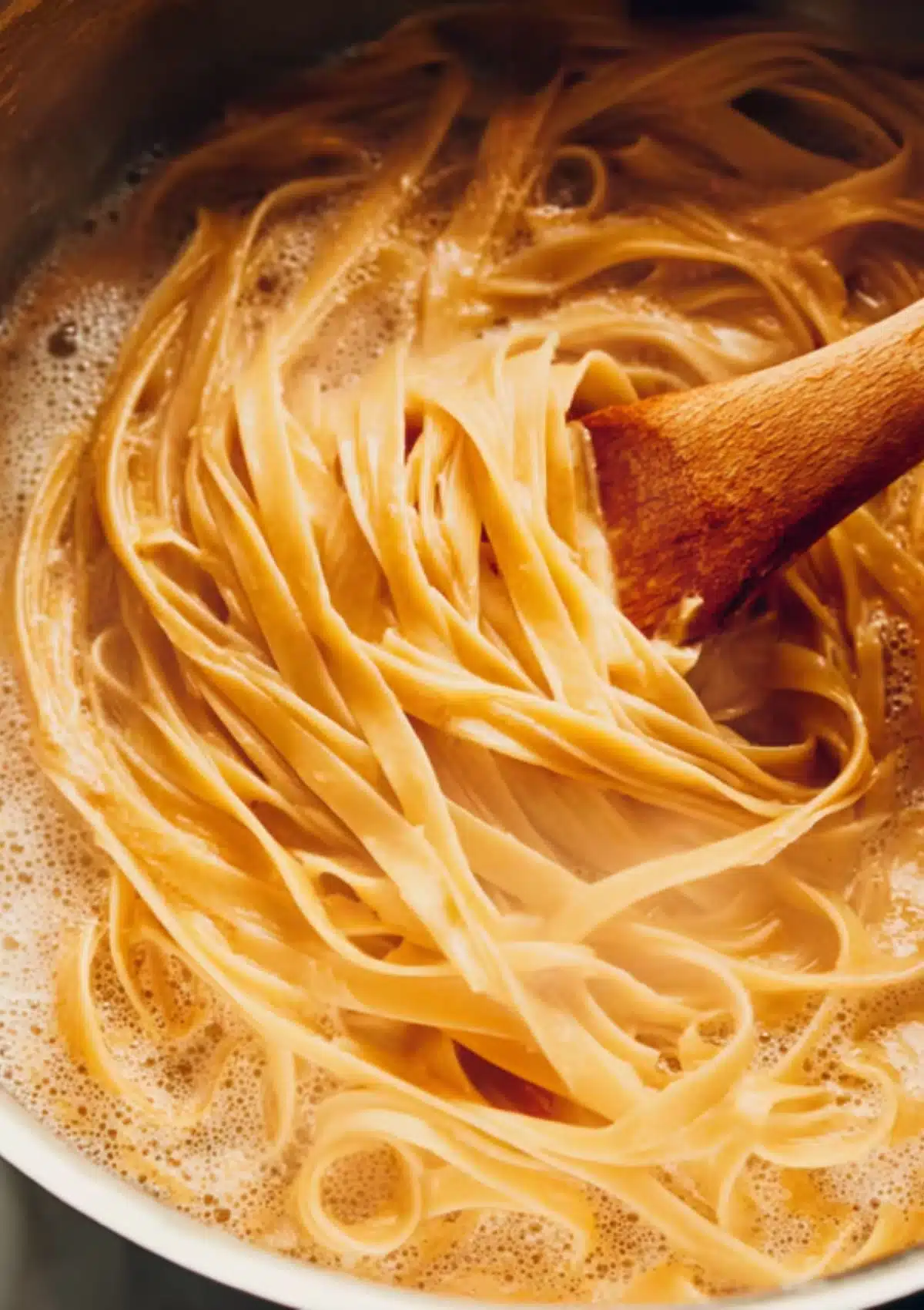 Fettuccine pasta cooking in boiling water