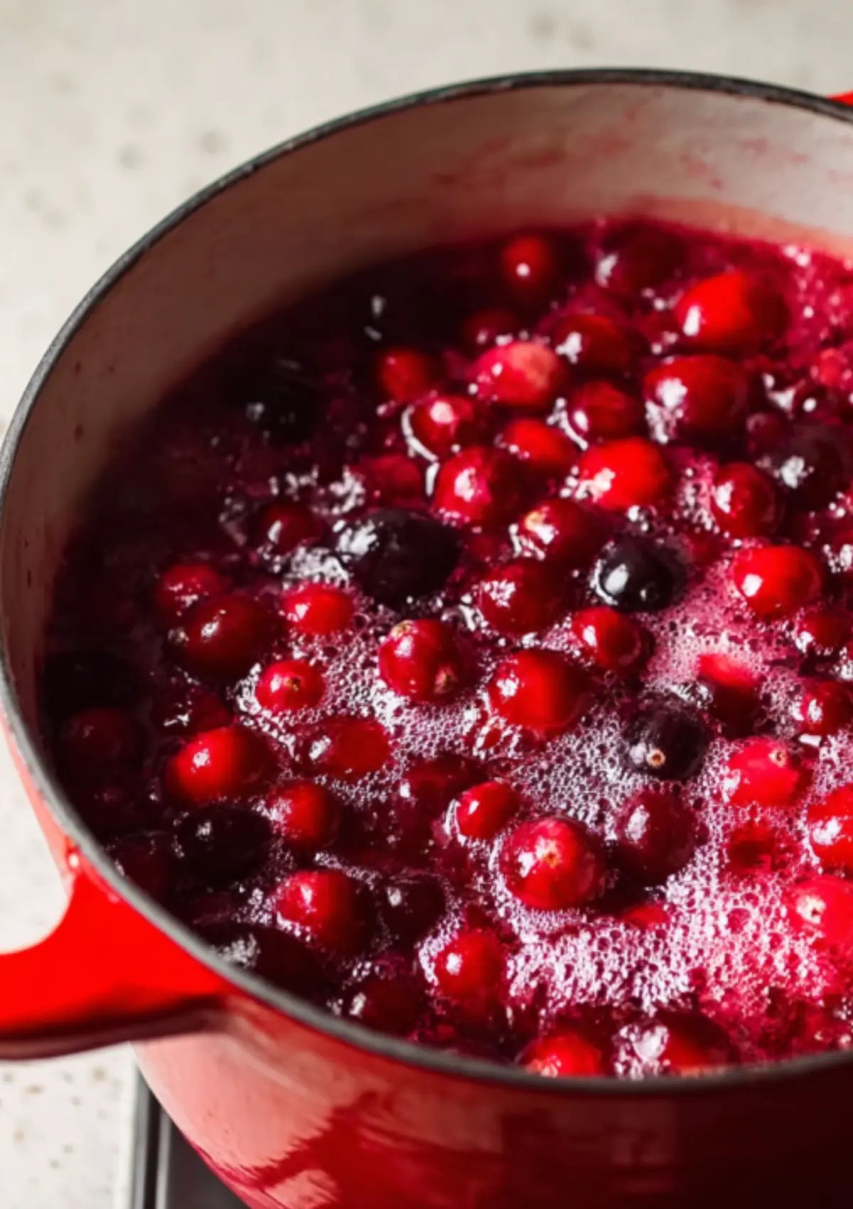 Fresh cranberries cooking in red pot