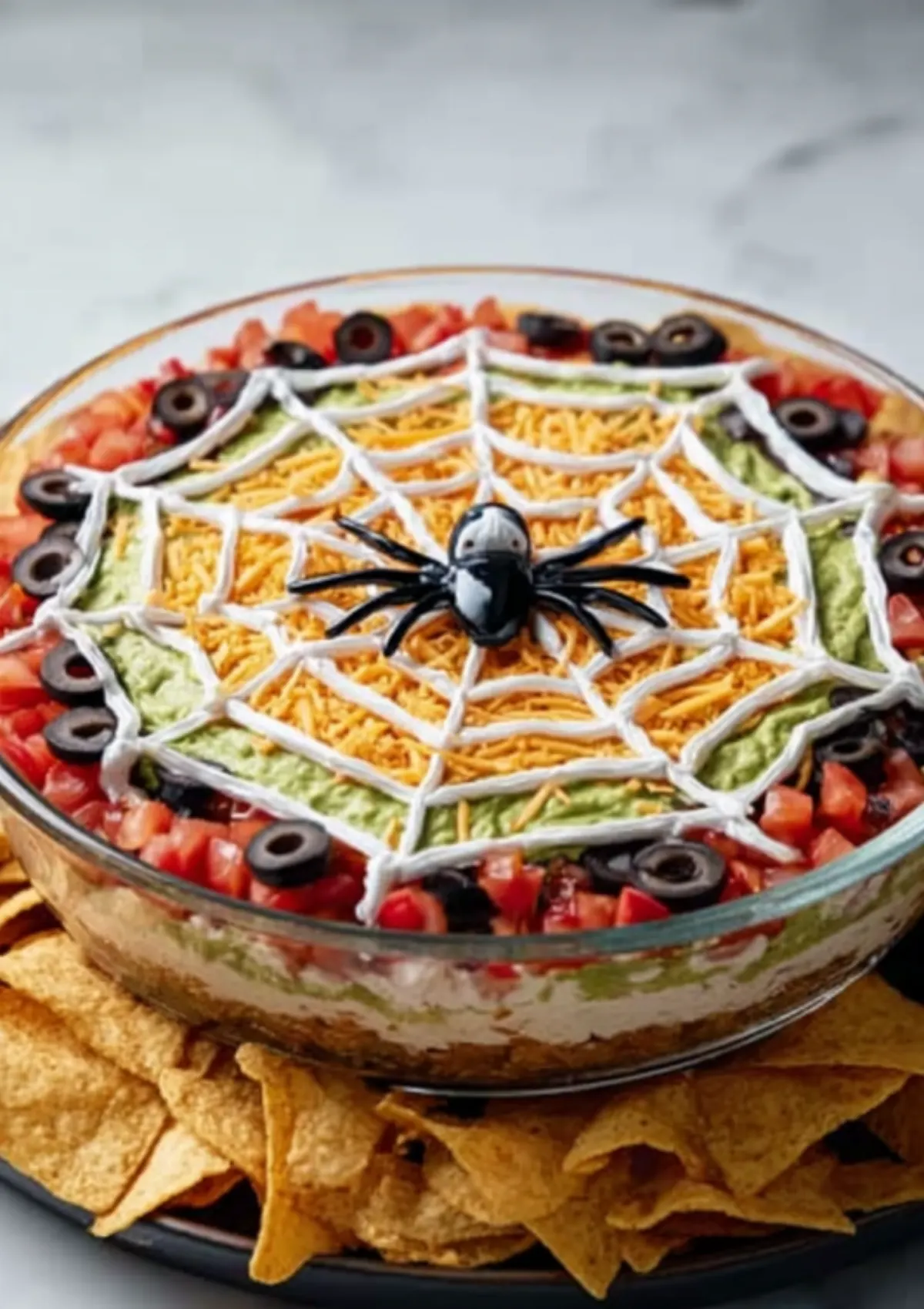 Halloween spiderweb layer dip in glass bowl with chips