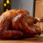 Mahogany-colored fried turkey on wooden board