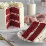 Red velvet cake with slice on plate, side view