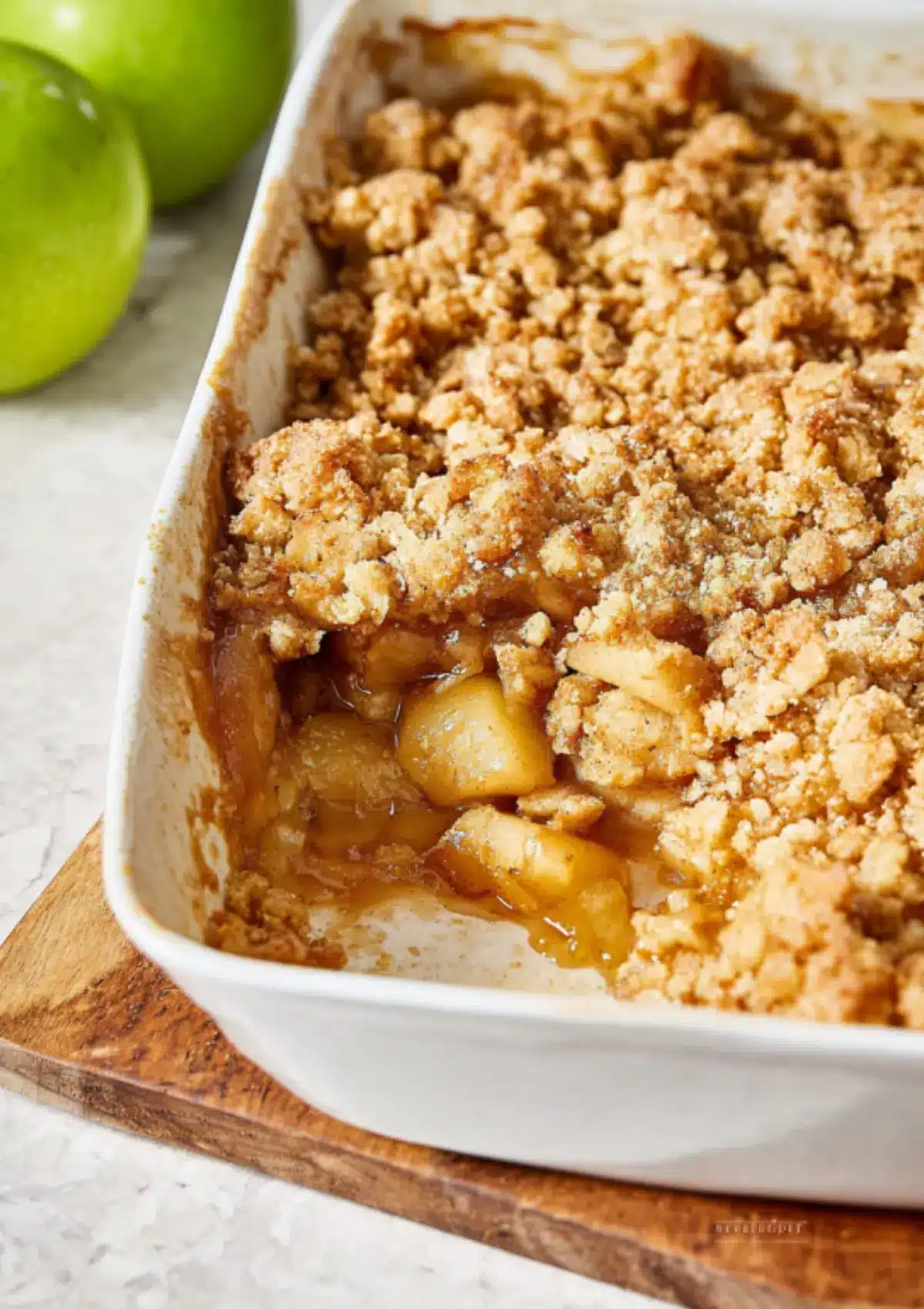 Apple crumble with portion removed showing filling