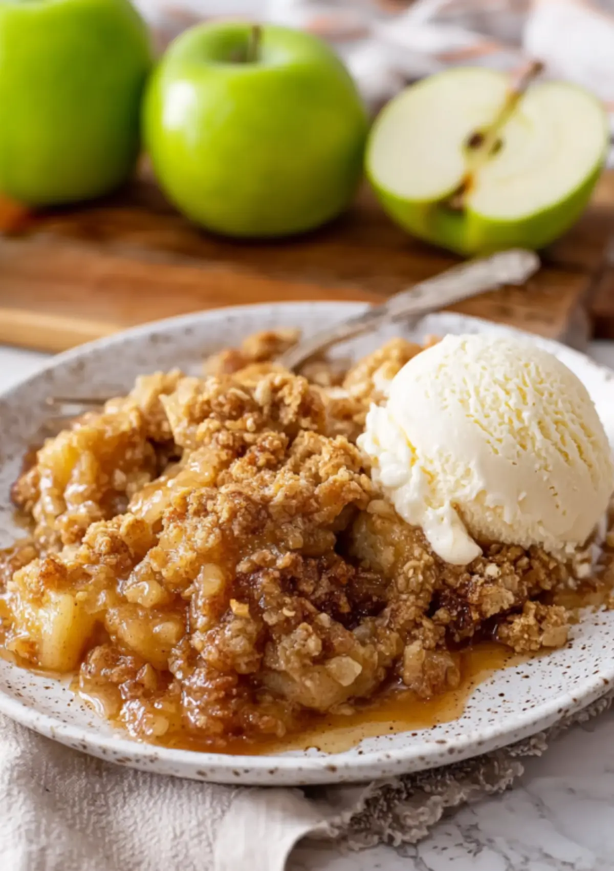 Apple crumble with vanilla ice cream on white plate