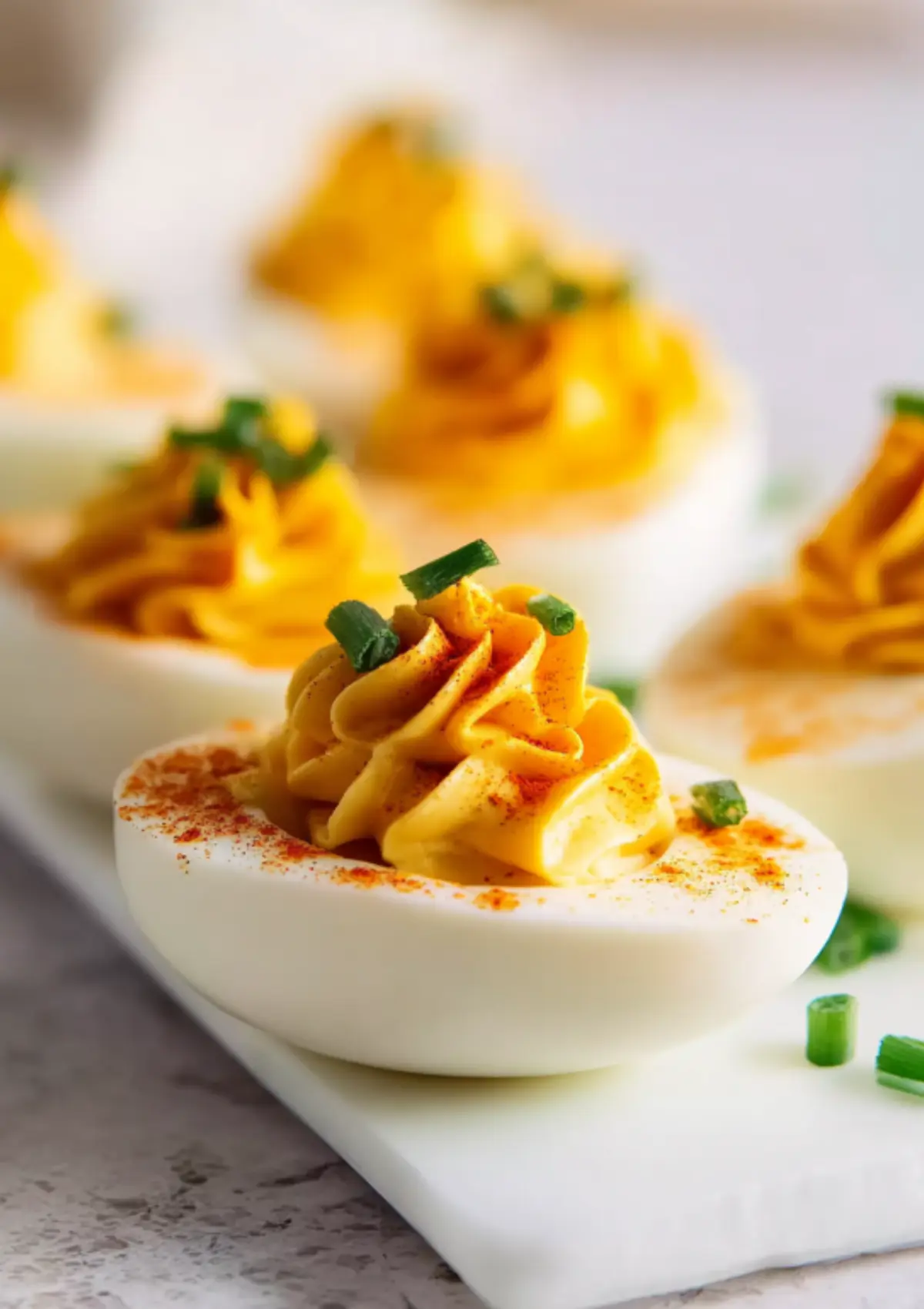 Single deviled egg with piped filling and chive topping