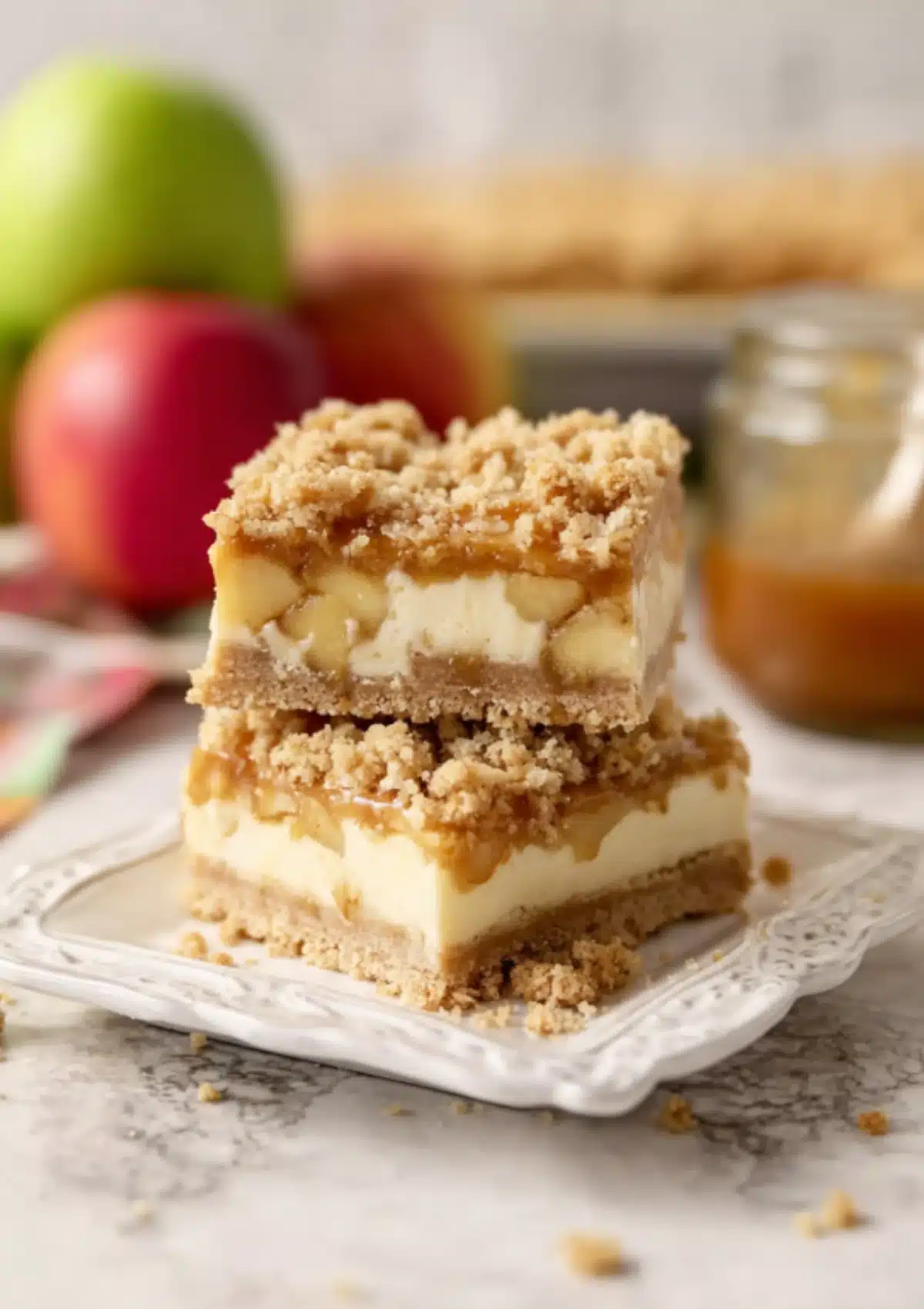 Two caramel apple cheesecake bars on white plate